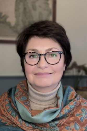 head and shoulders portrait of smiling adult with glasses, Maria Sokolova