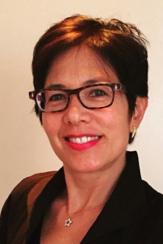 A woman with glasses confidently smiling at the camera