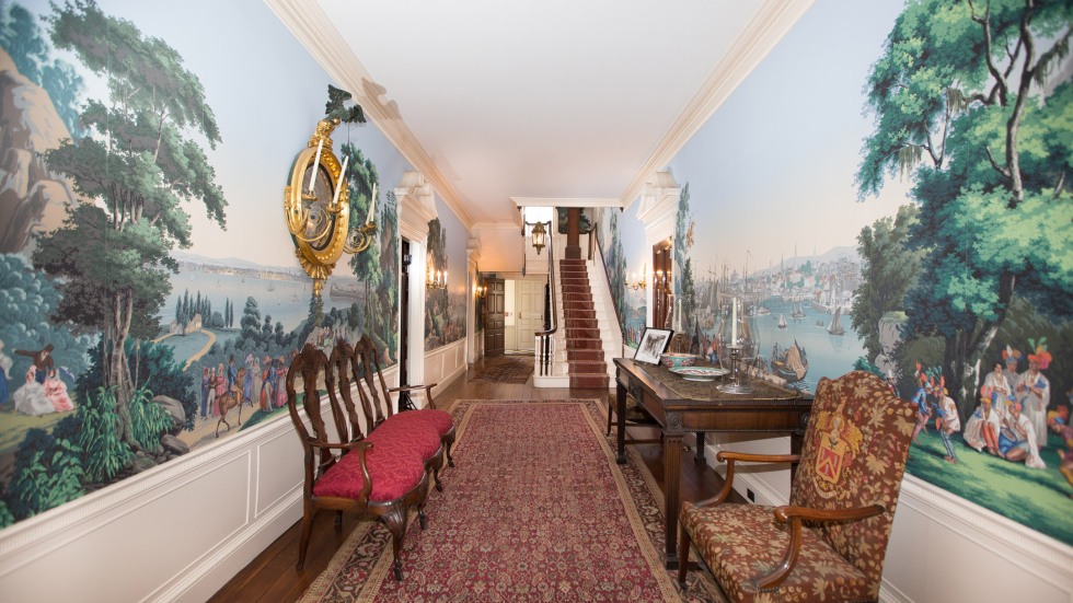 wallpapered hallway with furniture along walls