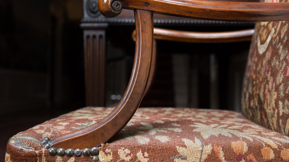 side view of an antique upholstered arm chair.